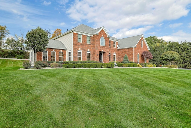 view of front of house with brick siding and a front lawn