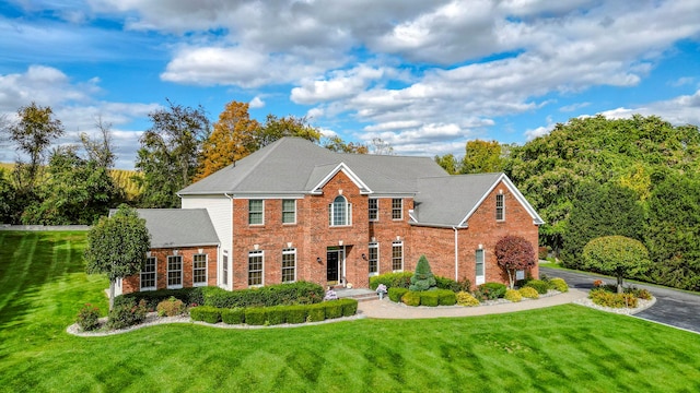 view of front of house with a front lawn and brick siding