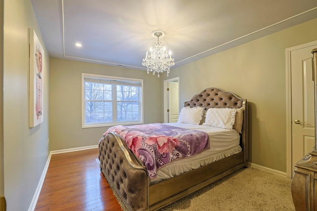 bedroom featuring a chandelier, baseboards, and wood finished floors