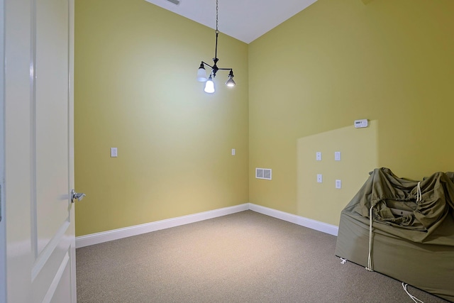 empty room featuring lofted ceiling, carpet, visible vents, and baseboards