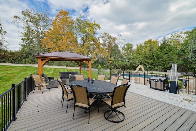 deck featuring a fenced in pool, a lawn, a gazebo, outdoor dining space, and fence