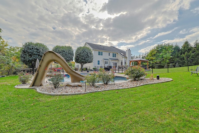 view of playground with fence, a lawn, and a gazebo