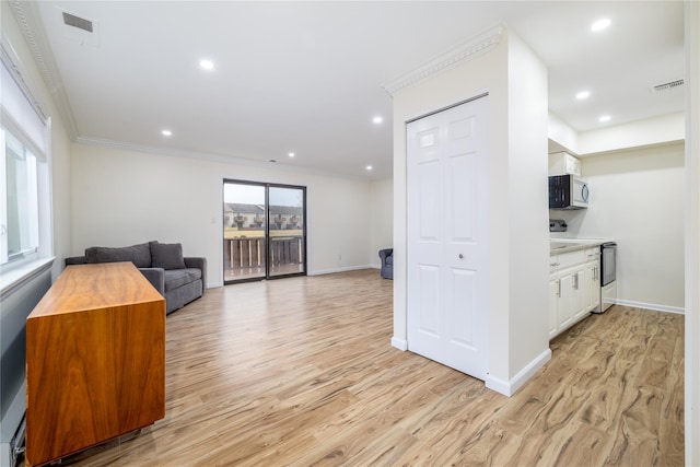 interior space with ornamental molding, light wood finished floors, and recessed lighting