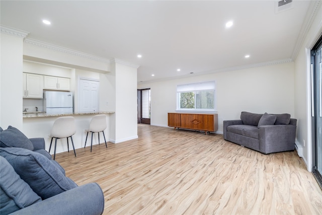 living room featuring recessed lighting, visible vents, baseboards, light wood-type flooring, and crown molding