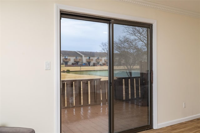 entryway featuring a water view, wood finished floors, and baseboards