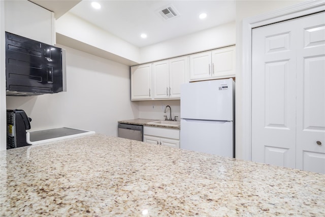 kitchen featuring visible vents, stove, freestanding refrigerator, a sink, and dishwasher