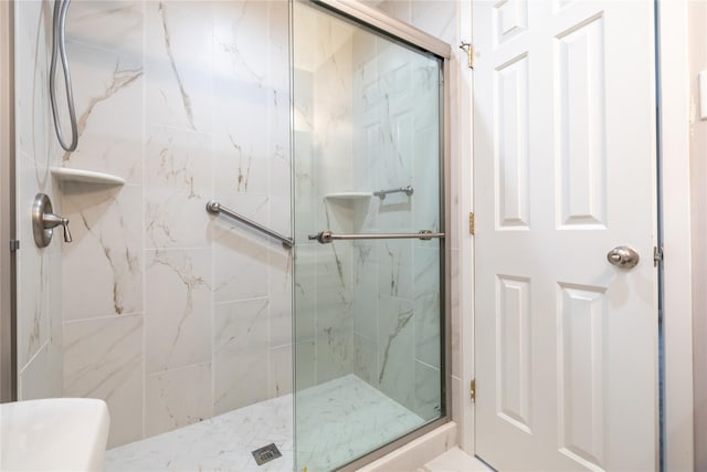 bathroom with a marble finish shower