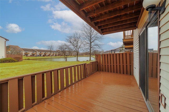 deck featuring a water view and a lawn