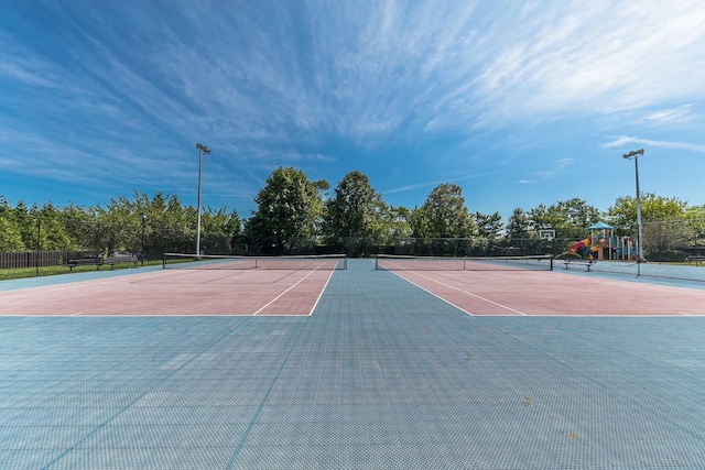 view of tennis court featuring community basketball court and fence