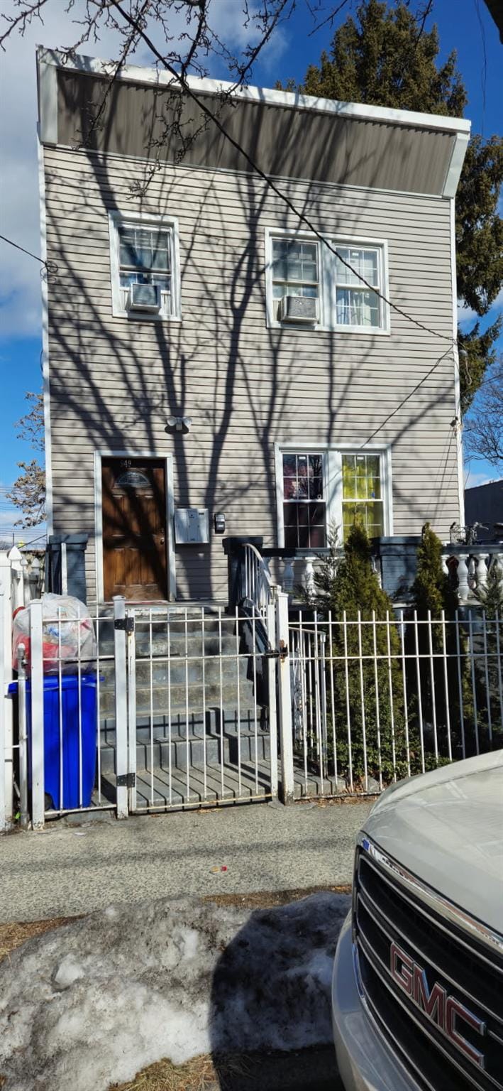 view of front of property with a fenced front yard and a gate