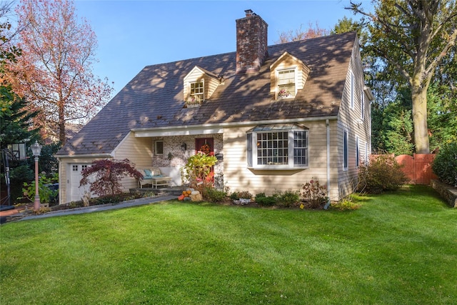 cape cod home with a chimney, a front yard, and fence