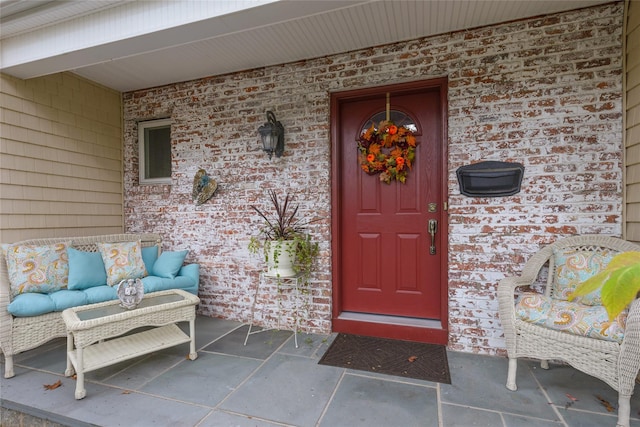 doorway to property with brick siding and an outdoor hangout area