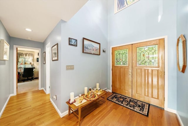 foyer featuring light wood-style flooring and baseboards