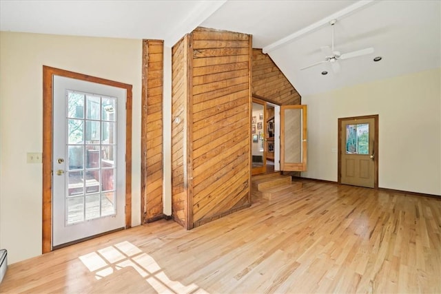 doorway with ceiling fan, a baseboard radiator, vaulted ceiling with beams, and wood finished floors