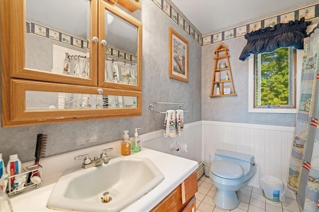 bathroom with toilet, tile patterned flooring, vanity, and wainscoting