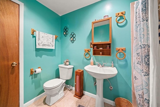 bathroom featuring a shower with shower curtain, tile patterned flooring, toilet, and baseboards