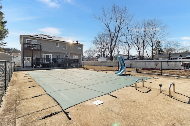 view of swimming pool with a fenced in pool, a patio area, a fenced backyard, and a water slide