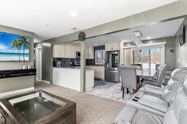 living area featuring baseboards, visible vents, and recessed lighting