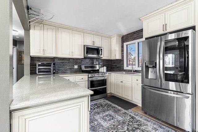 kitchen with stainless steel appliances, a toaster, a sink, and decorative backsplash