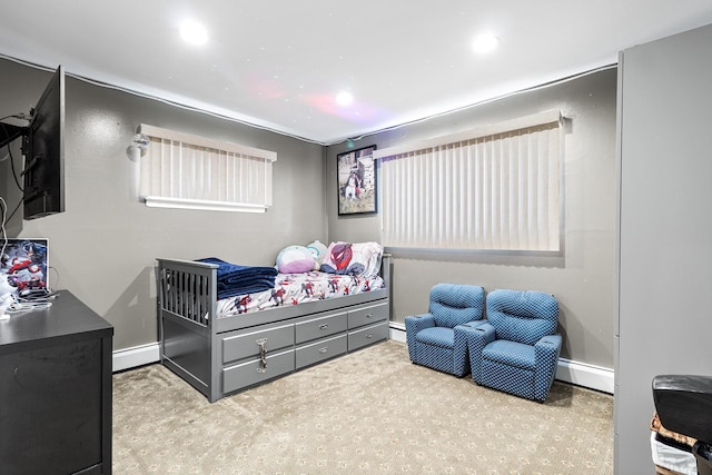 bedroom featuring a baseboard heating unit, carpet flooring, and baseboards