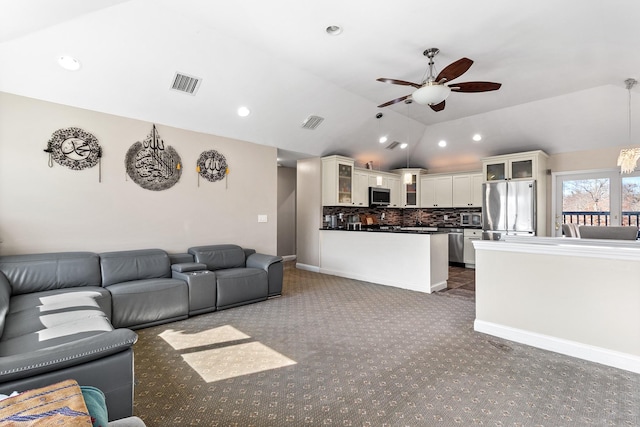 living area with carpet floors, visible vents, vaulted ceiling, and ceiling fan