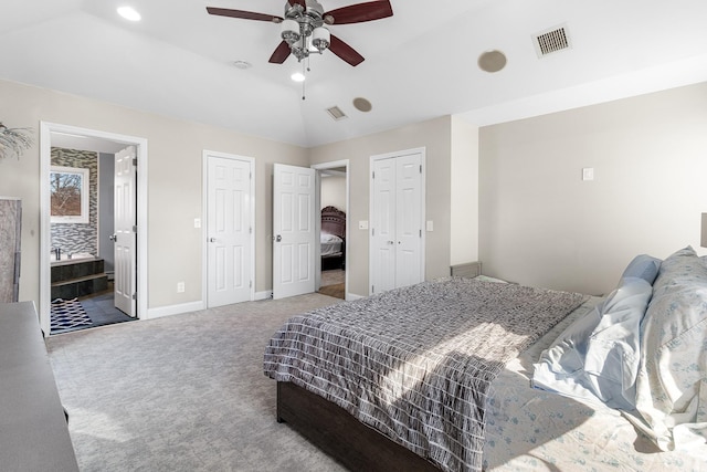 bedroom featuring carpet flooring, visible vents, baseboards, vaulted ceiling, and multiple closets