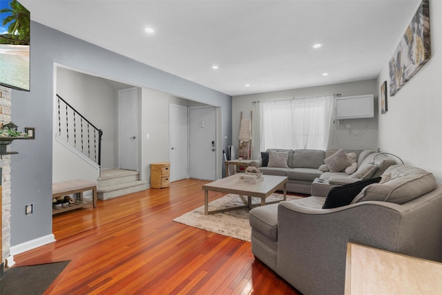 living area featuring stairs, recessed lighting, hardwood / wood-style floors, and a fireplace