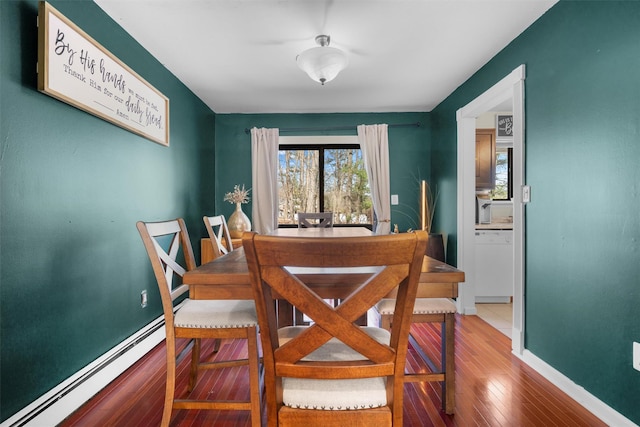 dining area with hardwood / wood-style floors, baseboards, and baseboard heating