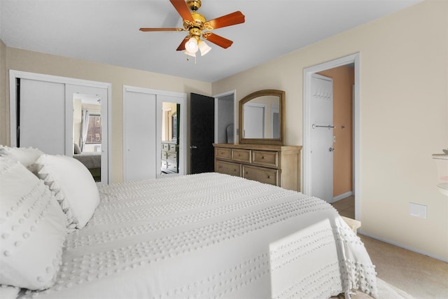 bedroom featuring carpet, baseboards, two closets, and ceiling fan