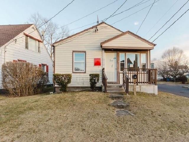 bungalow-style house with a porch and a front lawn