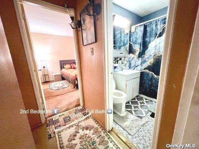 full bathroom with ensuite bathroom, toilet, vanity, and curtained shower