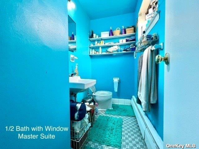 bathroom featuring toilet, a baseboard radiator, and tile patterned flooring