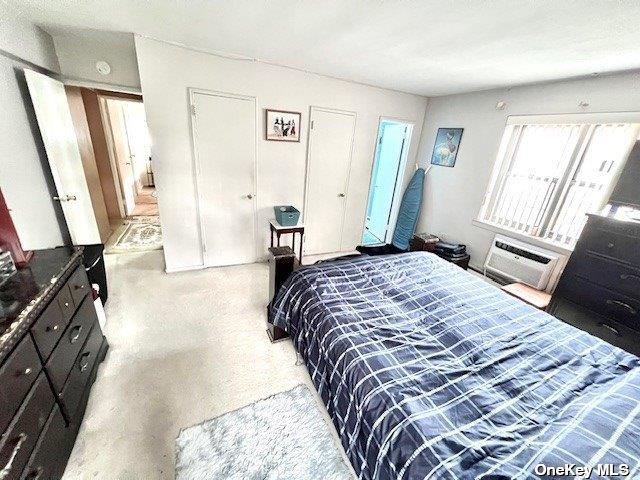 bedroom featuring speckled floor and a wall mounted AC