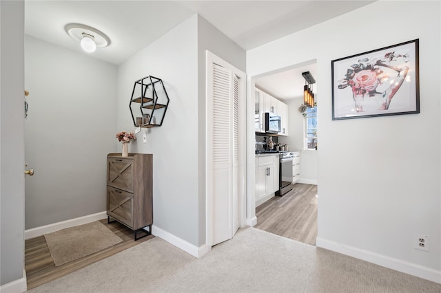 hallway with light wood finished floors and baseboards