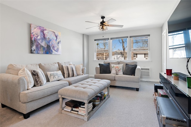 carpeted living area featuring a wall unit AC and ceiling fan