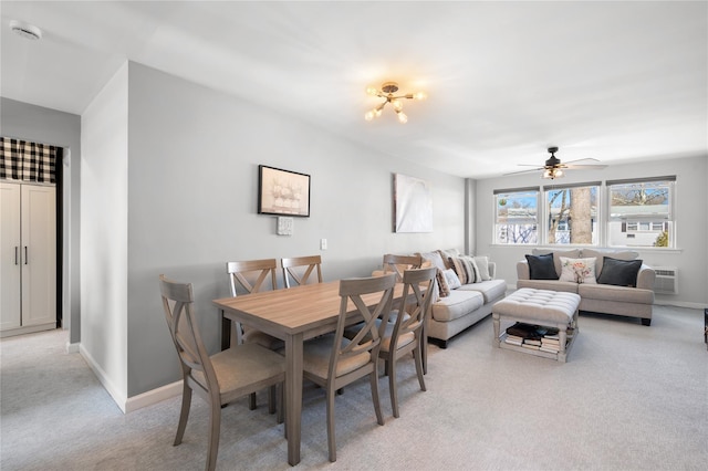 dining room featuring a ceiling fan, an AC wall unit, light carpet, and baseboards