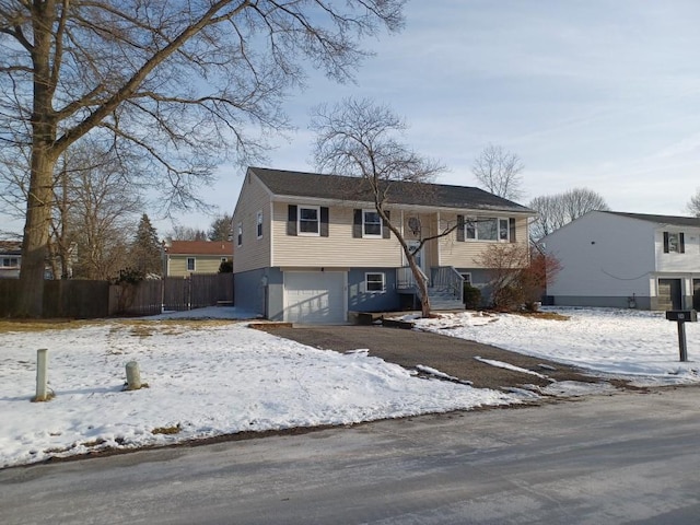 bi-level home with a garage and fence