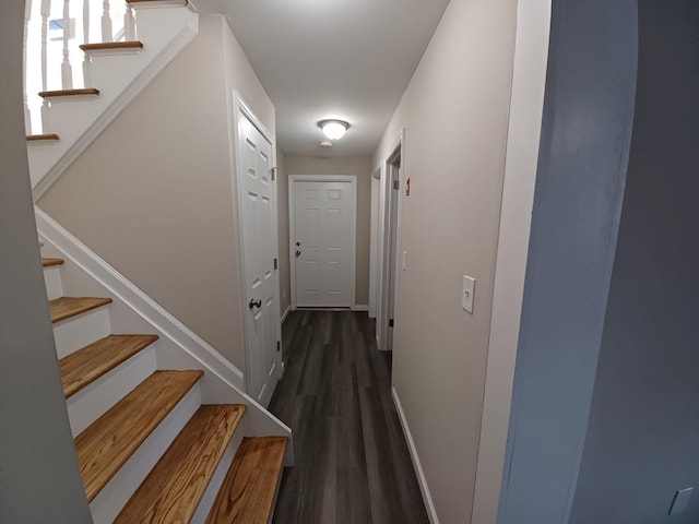 hallway with stairs, wood finished floors, and baseboards