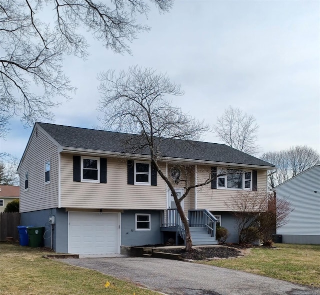 54 Brewster Dr, Middletown, NY 10940 - bi-level home with aphalt driveway, a garage, and a front lawn
