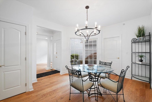 dining space with light wood-style floors, a notable chandelier, and baseboards