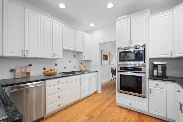 kitchen with tasteful backsplash, recessed lighting, appliances with stainless steel finishes, and white cabinetry
