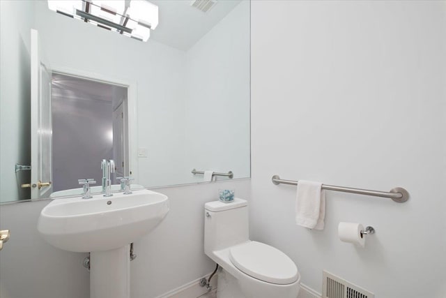 half bath featuring visible vents, toilet, and baseboards