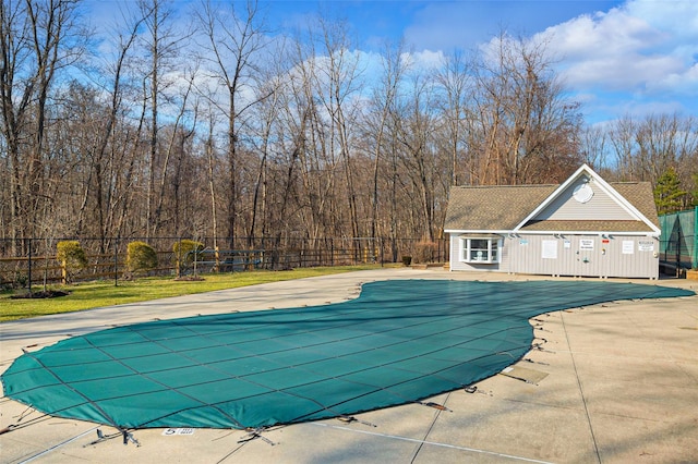 community pool featuring a patio, an outbuilding, an exterior structure, and fence