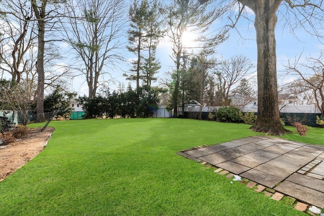 view of yard with an outbuilding, a patio area, and fence