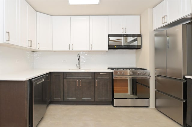 kitchen featuring light countertops, appliances with stainless steel finishes, a sink, and white cabinetry