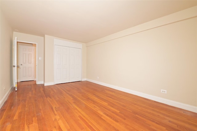 unfurnished bedroom with a closet, light wood-type flooring, and baseboards