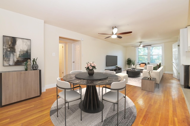 dining area featuring light wood-style flooring and baseboards