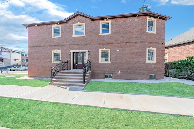 view of front of house with a front yard and brick siding