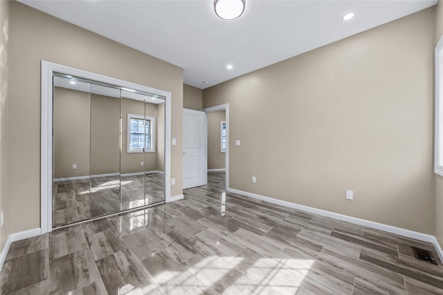 unfurnished bedroom with baseboards, a closet, and recessed lighting