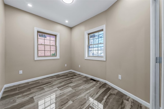 unfurnished room featuring visible vents, baseboards, wood finished floors, and recessed lighting